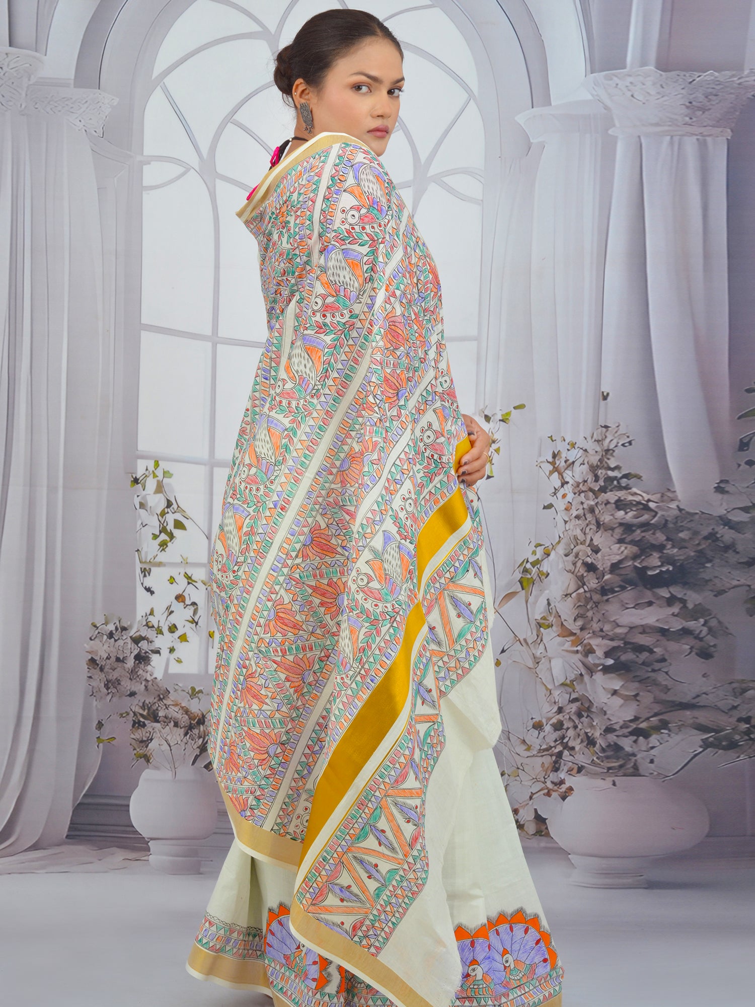 White Kerala saree featuring floral Madhubani art and golden zari edging