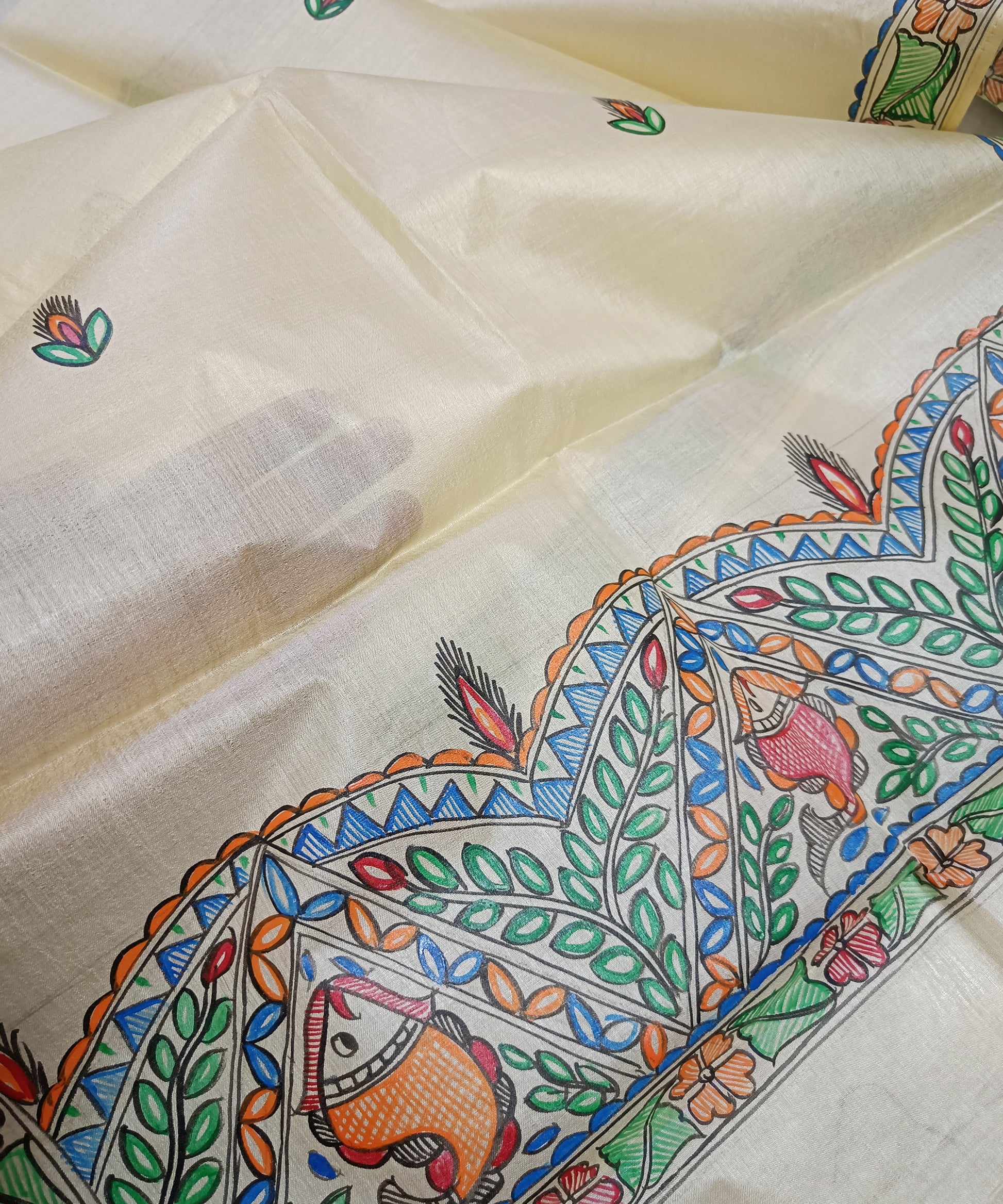 Hand-painted Madhubani Tussar silk stole with colorful traditional fish and floral motifs on a natural cream background