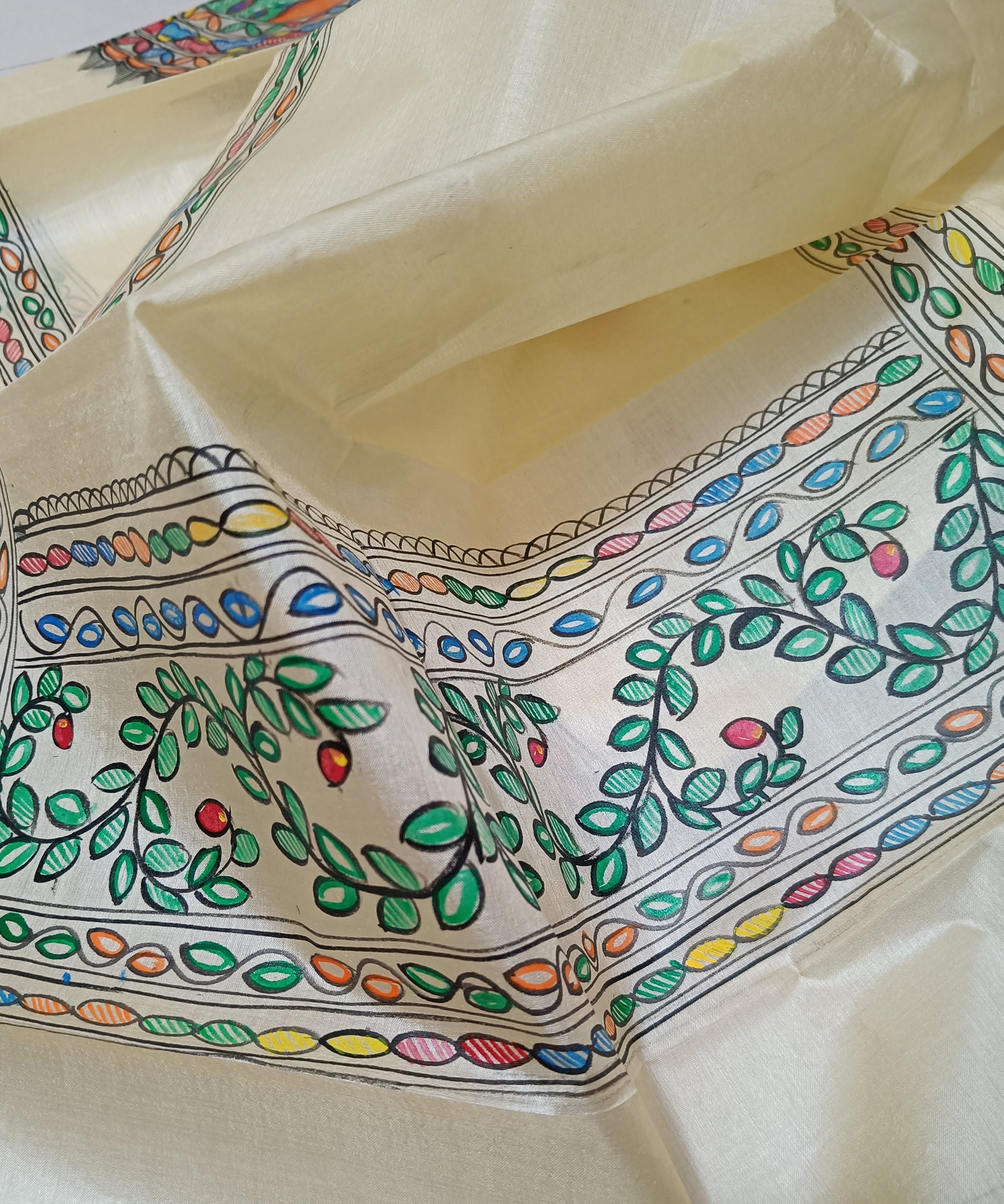 Natural cream Madhubani Tussar silk stole featuring a colorful central circular peacock mandala and green leafy vine borders